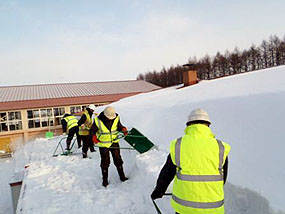 児童玄関の屋根を除雪する職員たち