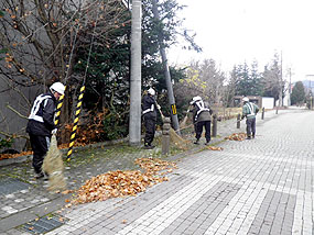 落ち葉などを清掃する職員たち