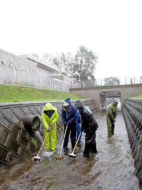 公園内の水路を清掃する職員たち