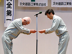 決議宣言を受け取る澤口社長（左側）
