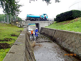 散水車を使い水路内を清掃する参加者たち