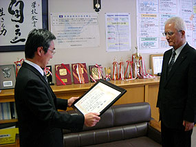 河原校長（左）から感謝状を受け取る澤口社長（右）
