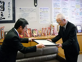 河原校長（左）から感謝状を受け取る澤口社長（右）
