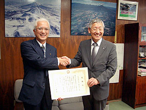 片山ニセコ町長と握手をする澤口社長（左）